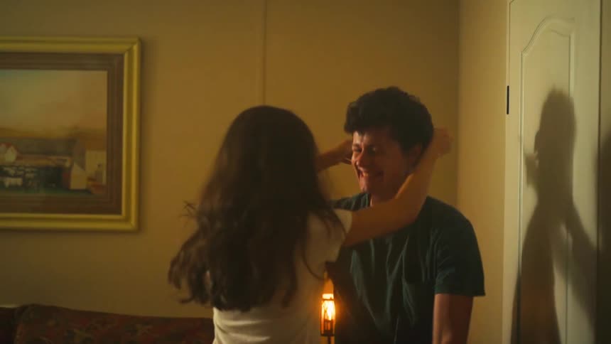 A young woman reveals her positive pregnancy test to her partner, and they share a joyful, loving embrace in slow motion
