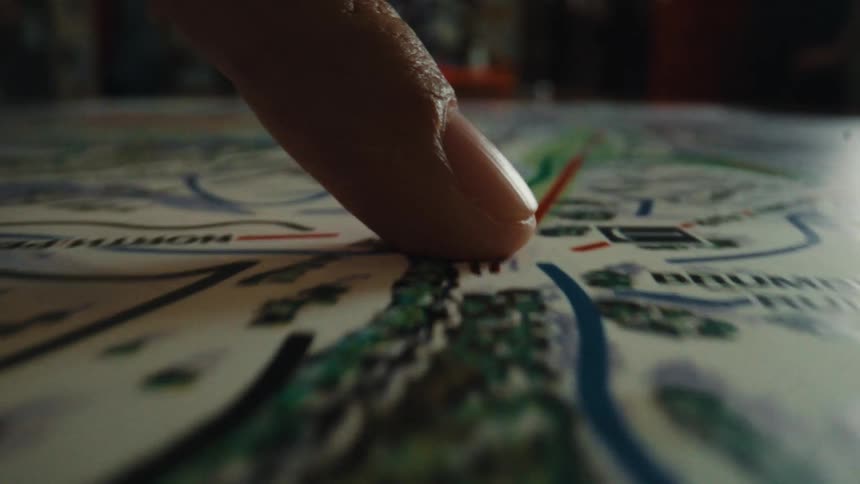 A close-up shot of a finger tracing a planned route on a ski resort trail map