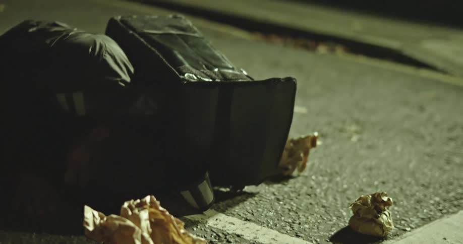 The aftermath of a tragic accident shows a food delivery driver lying unconscious on a dark street