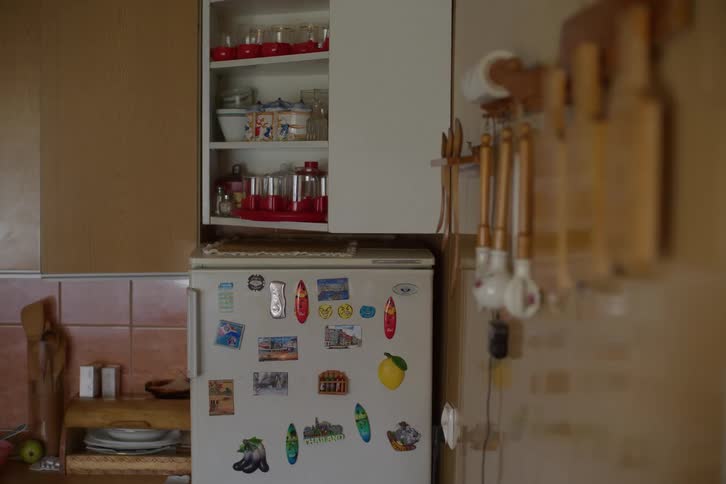 A nostalgic view of a cozy, lived-in kitchen with a refrigerator covered in travel magnets