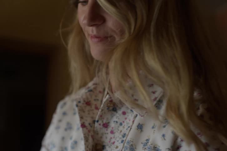 Softly lit portrait of a smiling young woman with blonde hair turning her head