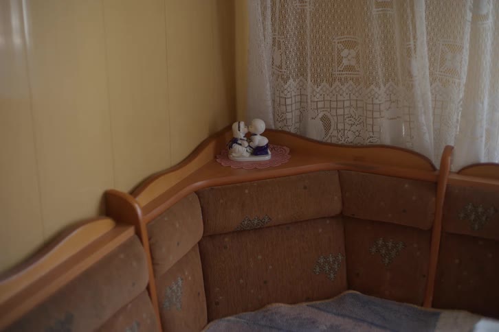 A cozy and nostalgic interior corner with a vintage-style sofa and a small porcelain figurine of a loving couple