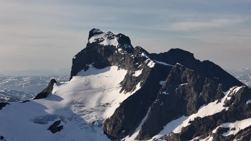A majestic timelapse of shadows moving across a rugged, snow-covered mountain peak and its vast glacier