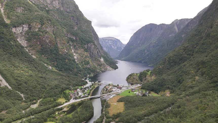 A stunning aerial view of a picturesque Norwegian village situated at the end of a majestic, steep-sided fjord