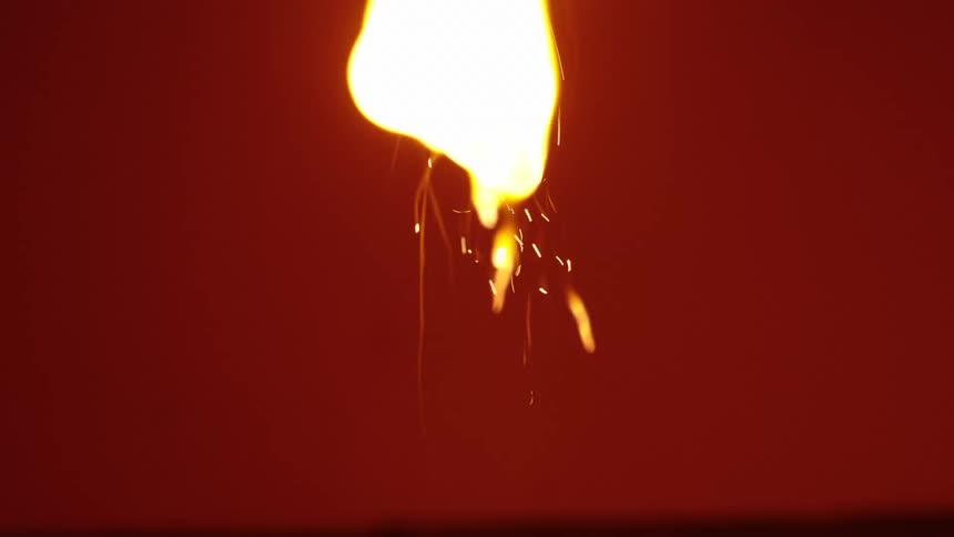 A fuse is lit with a lighter and burns brightly with sparks against a black background in slow motion