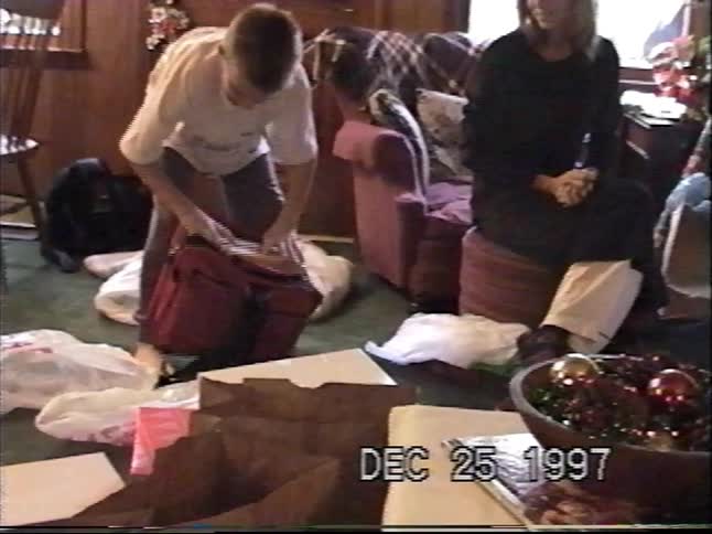 A young boy opens his presents on Christmas morning in 1997, revealing a new video game console