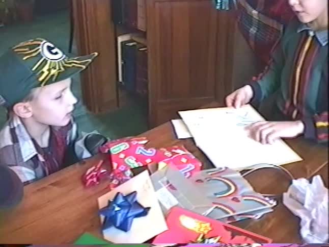 Vintage 90s home video footage of a young boy opening a birthday card surrounded by his family and friends