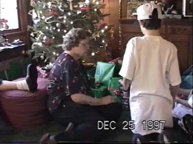 Vintage 1997 home video captures a family gathered around the Christmas tree to open presents on Christmas morning