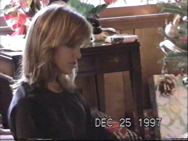 A woman and her son look at a new atlas together in front of a Christmas tree in 1997