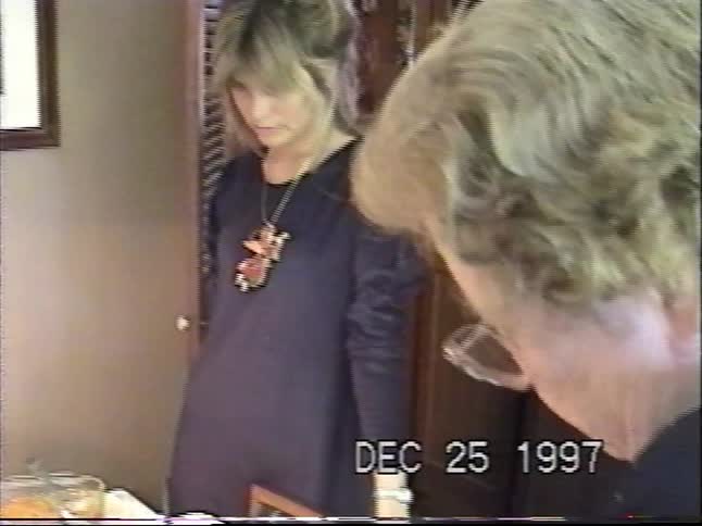A classic 1990s home video captures a family gathering around a festive dinner table on Christmas Day