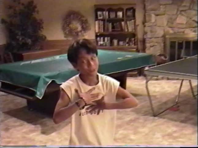 Vintage 1990s home movie footage of a basement game room with young boys playing and being silly for the camera