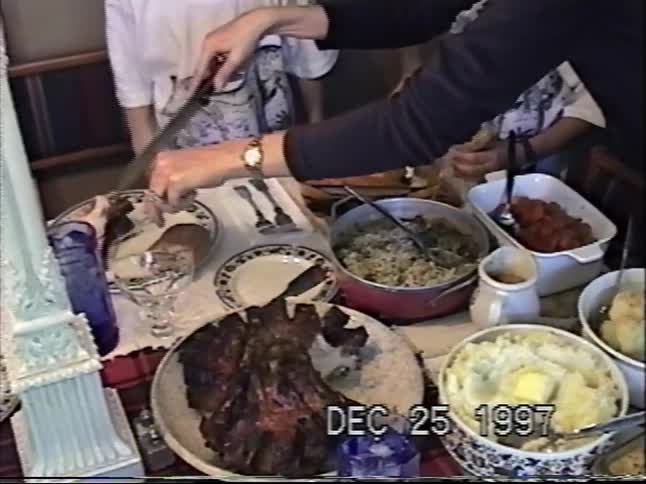 A woman carves a prime rib roast as part of a large family Christmas dinner in 1997