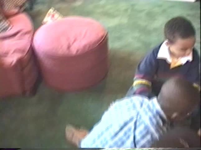 Excited children gather on the floor at a birthday party to open their goody bags filled with candy and toys