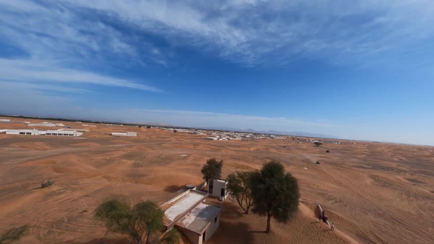 An FPV drone soars over the eerie, sand-swallowed ghost town of Al Madam in the Sharjah desert, exploring its abandoned buildings
