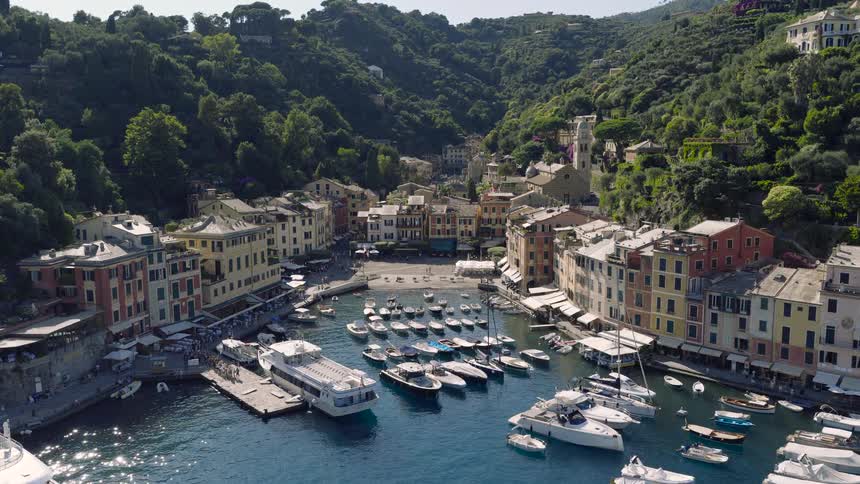 A beautiful timelapse of the harbor of Portofino, Italy, with boats moving in the water and tourists walking on the pier