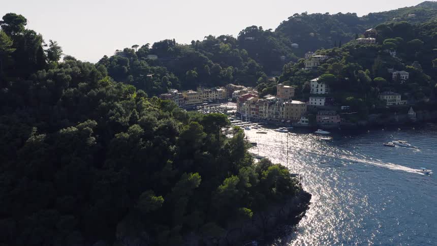 A slow aerial reveal of the stunning seaside village of Portofino, Italy, showcasing its famous harbor filled with yachts and colorful houses