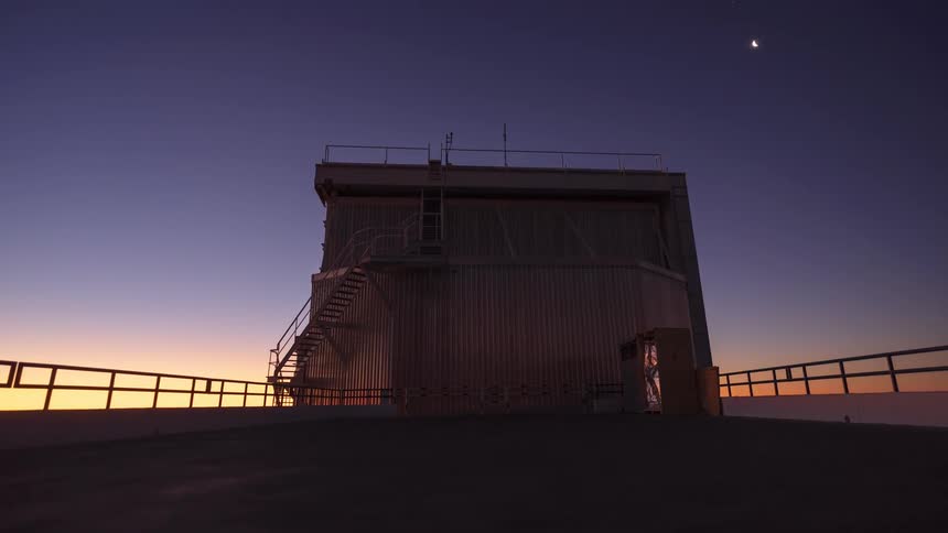 Day-to-night timelapse captures an astronomical observatory opening up for observation as the sun sets and the moon and stars appear in the sky