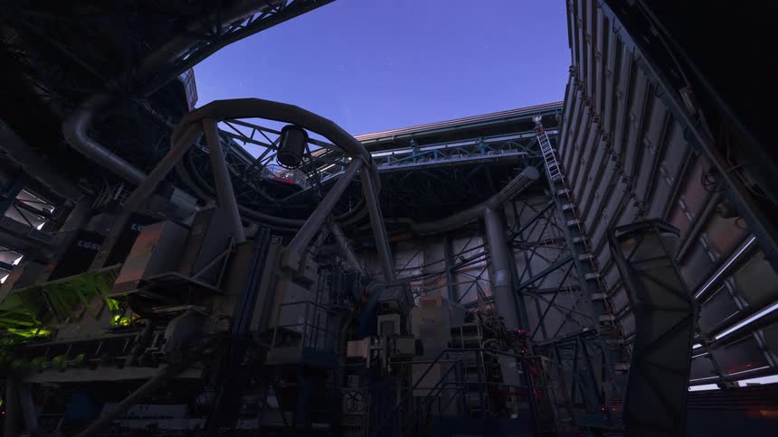 Timelapse of a powerful telescope inside a large observatory as the dome opens and it operates from sunset into a starry night