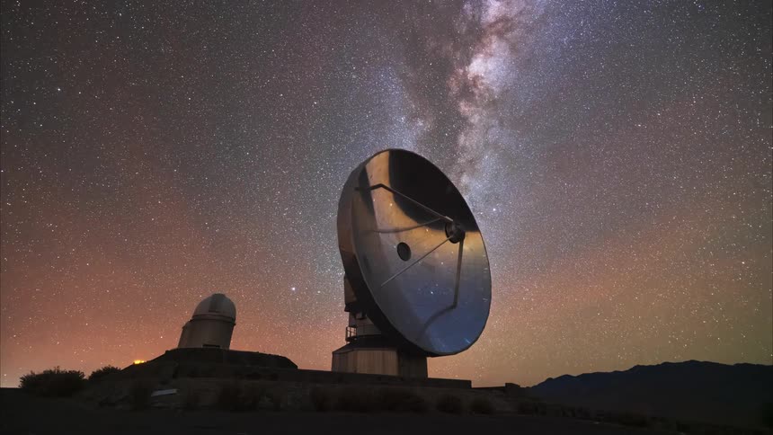 A massive radio telescope points towards the heavens as the Milky Way galaxy majestically passes by in a breathtaking night sky time-lapse