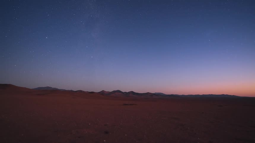A stunning day-to-night timelapse shows the sun setting over a vast desert, revealing a brilliant Milky Way and starry sky before a bright moonrise