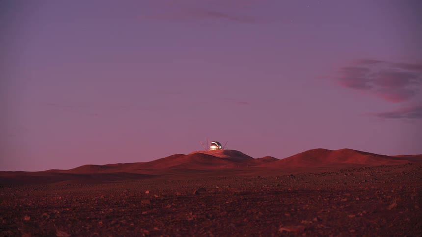 A stunning day-to-night timelapse shows a colorful sunset over a remote desert observatory as stars fill the night sky