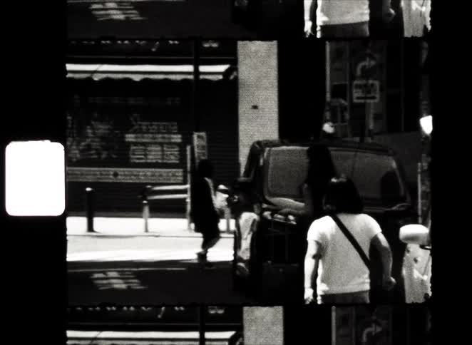 Gritty black and white 8mm film captures people walking on a city street in a split-screen, film strip style