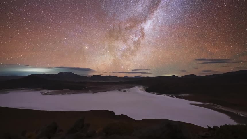 A stunning day-to-night timelapse captures the Milky Way galaxy appearing in the starry sky over a mountain salt flat
