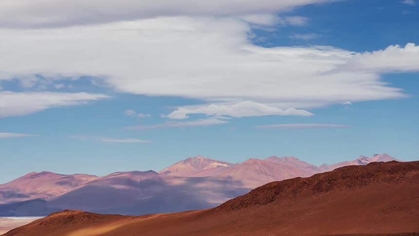A beautiful time-lapse of cloud shadows moving across a colorful and arid mountain desert landscape
