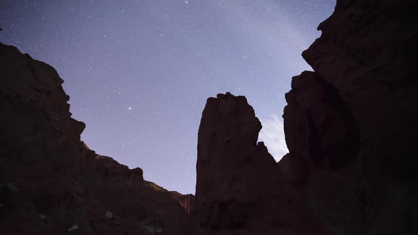 A stunning day-to-night-to-day timelapse of the starry sky, Milky Way, and moonrise over majestic red rock canyon formations