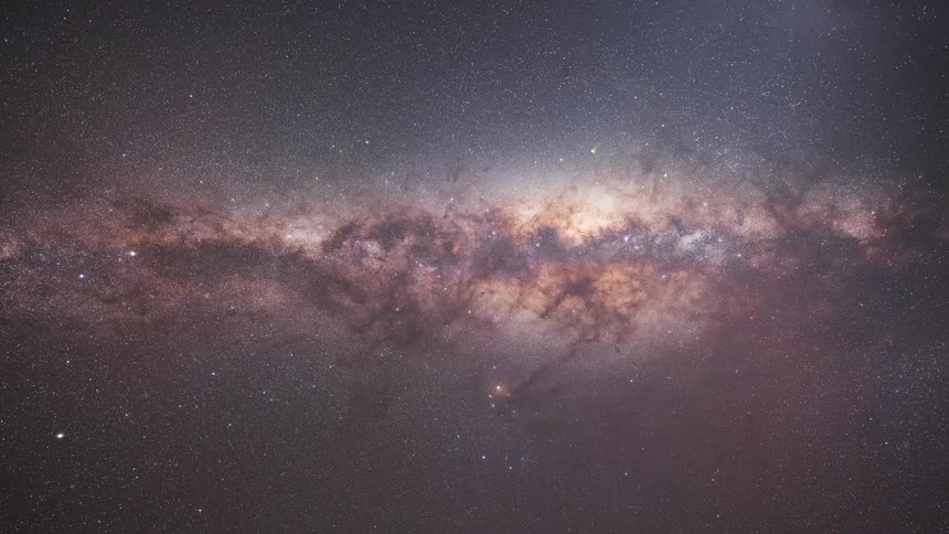 A vertical timelapse captures the colorful Milky Way galaxy rotating through the night sky and fading into the blue light of dawn