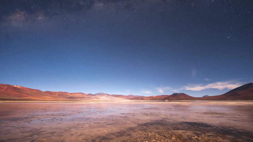 A stunning day-to-night timelapse over a tranquil mountain lake reveals a breathtaking starry sky and the Milky Way galaxy
