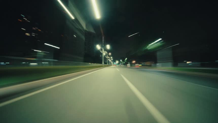A dynamic POV hyperlapse captures the experience of driving at high speed through an illuminated city at night