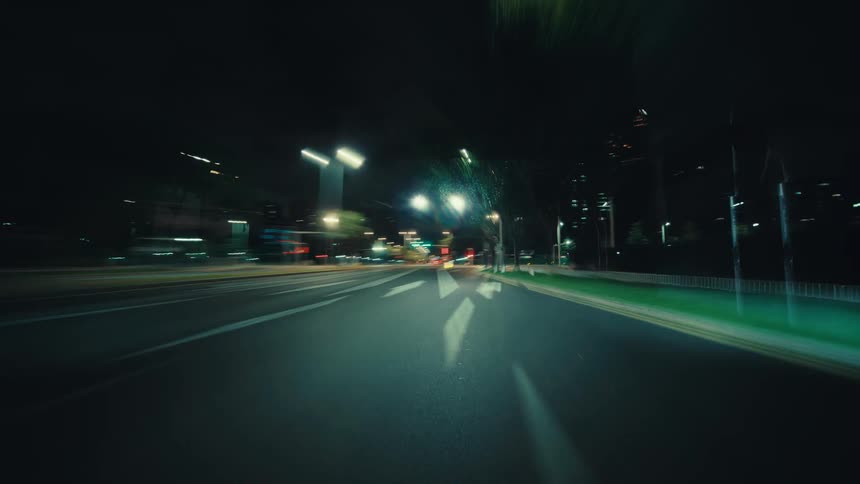An exhilarating point-of-view hyperlapse shows a car driving at high speed through a city at night