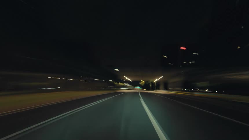 A thrilling POV hyperlapse of a car speeding through a modern city at night, with streaking lights and motion blur