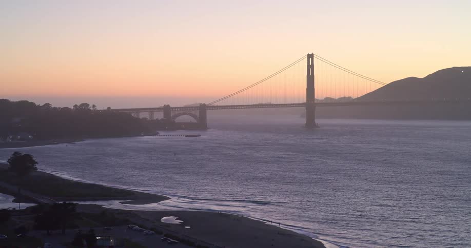A stunning aerial view of the iconic Golden Gate Bridge over the San Francisco Bay during a hazy sunset