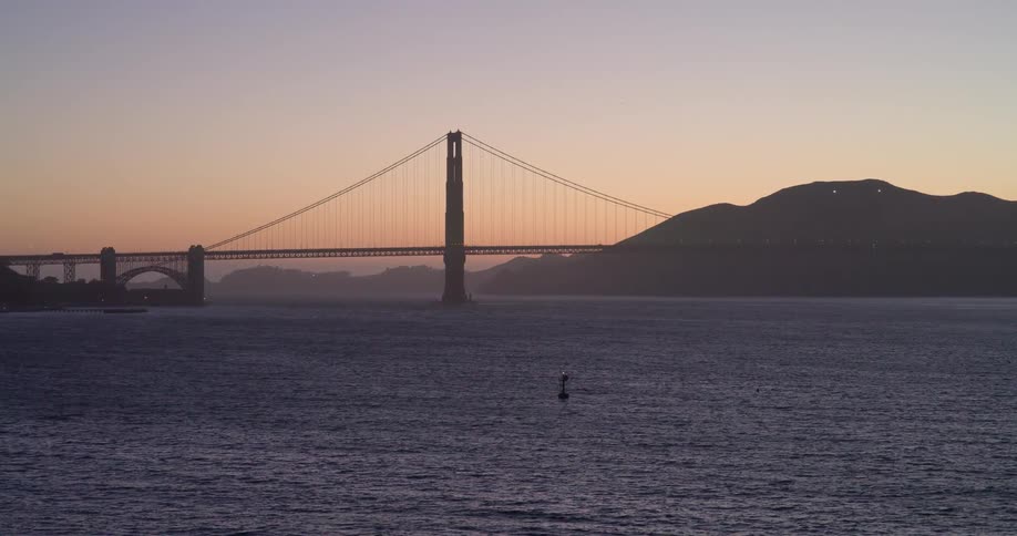 A tranquil, static view of the iconic Golden Gate Bridge over the San Francisco Bay at sunrise