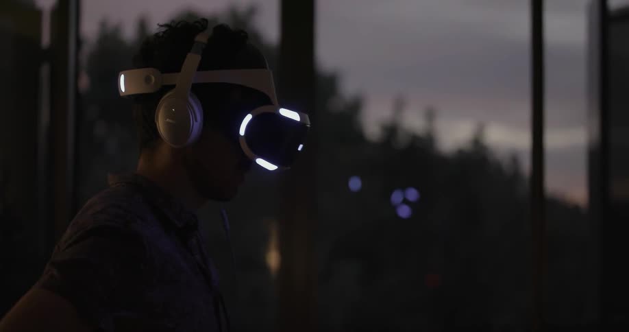 Man using some vr equipment indoors on a cloudy evening