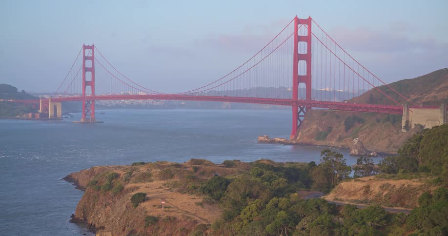 An aerial view reveals the majestic Golden Gate Bridge in San Francisco, spanning the bay against the backdrop of coastal hills