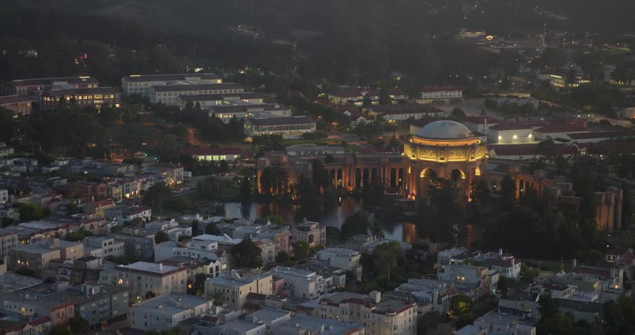 Twilight descends over San Francisco, with the iconic Palace of Fine Arts glowing warmly in a scenic cityscape view