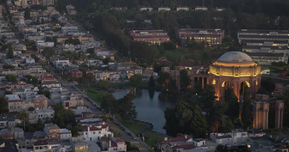 Stunning aerial view pulling back from the illuminated Palace of Fine Arts at dusk in San Francisco, California
