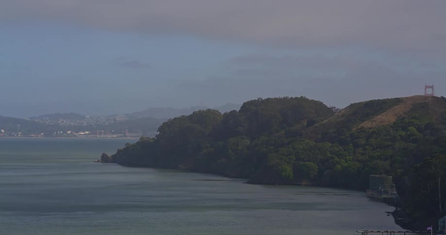 A slow aerial reveal of the famous Golden Gate Bridge and the San Francisco Bay on a cloudy day
