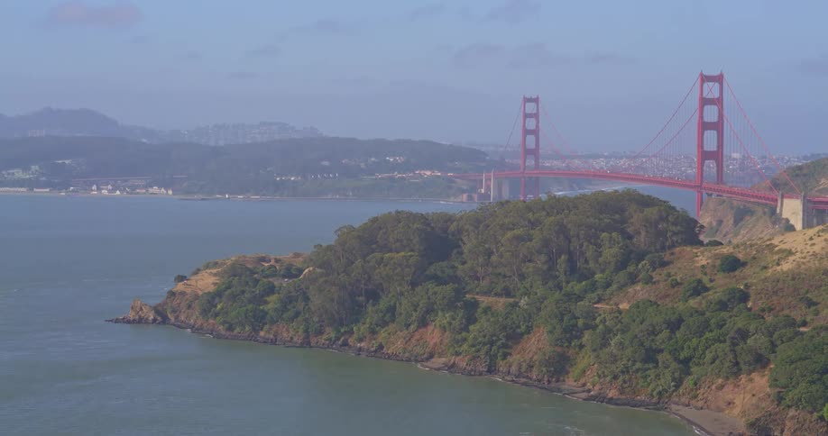 A scenic high-angle view of the iconic Golden Gate Bridge and the San Francisco Bay on a hazy day