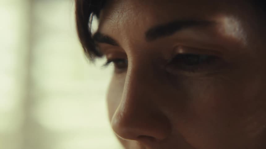 An intimate extreme close-up of a woman's eyes as she looks down and concentrates