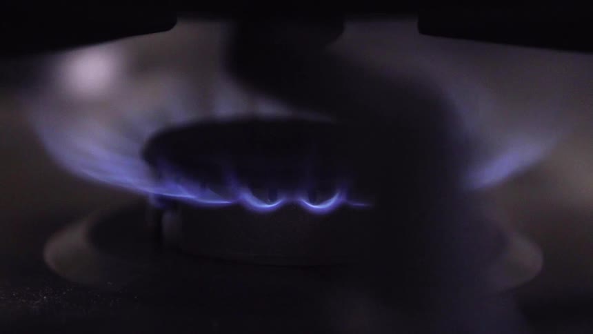 A flame on a burner glows blue
