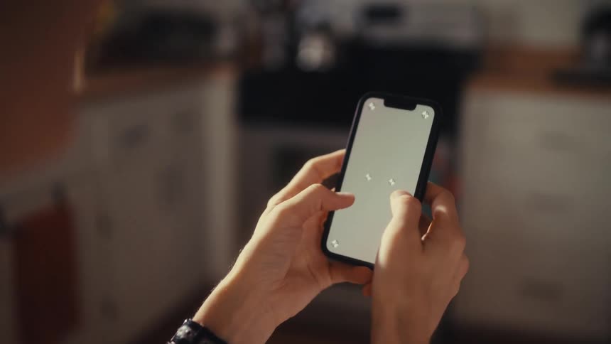 An over-the-shoulder view of a person using a smartphone with a blank screen ready for screen replacement