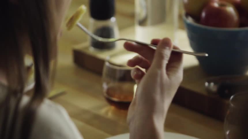 A woman takes a bit of her food