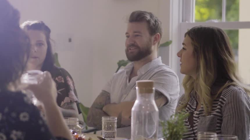 A group of dinner guests are talking and interacting