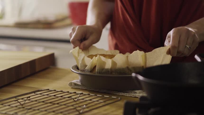 A person lifts a cake out of a pan