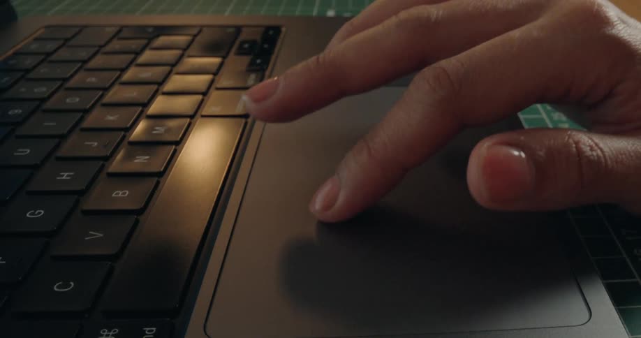 A close-up, seamless loop shows a finger scrolling and clicking on a laptop trackpad