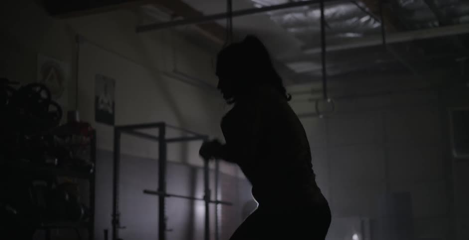 A woman kick boxes indoors